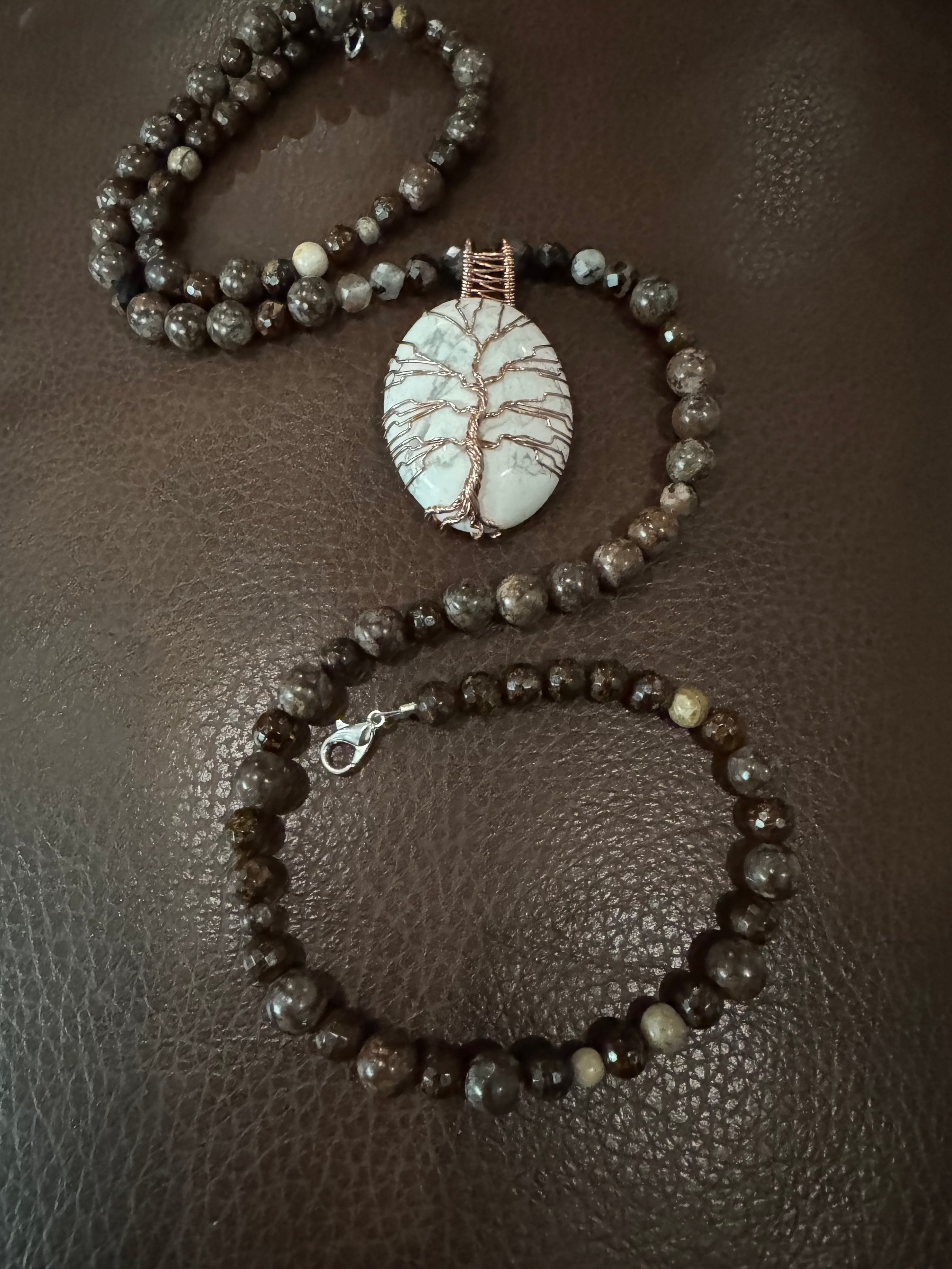 Beaded bracelet with a stone pendant on a brown textured surface